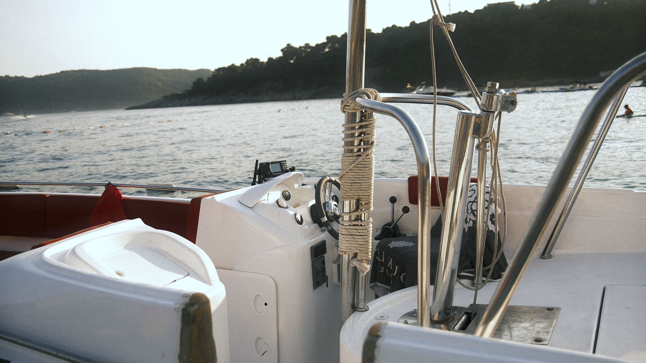 Looking out over calm water from the deck of a sailboat