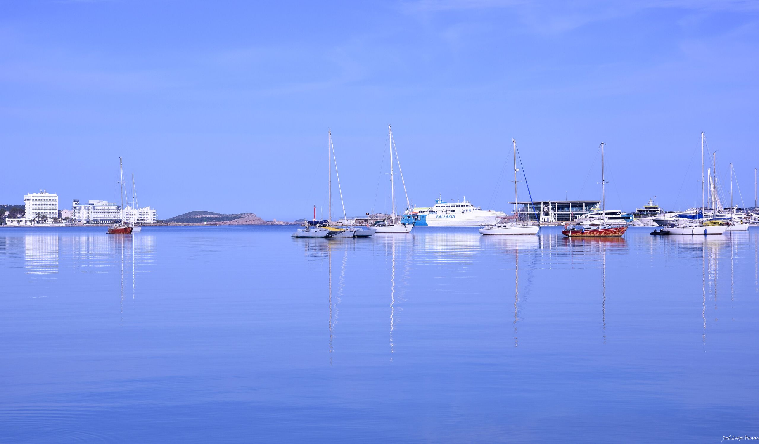 A sailboat gliding on glassy, calm water